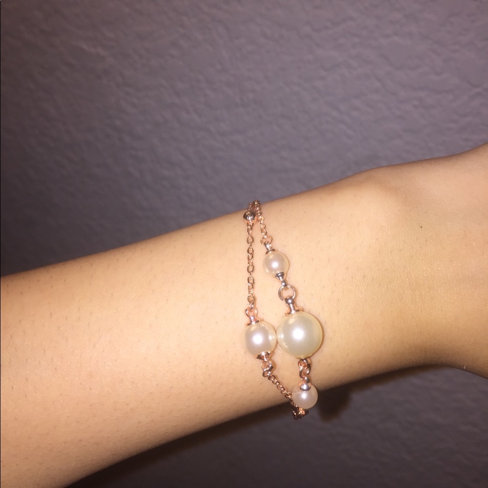 Rose gold bracelet with faux pearls.
